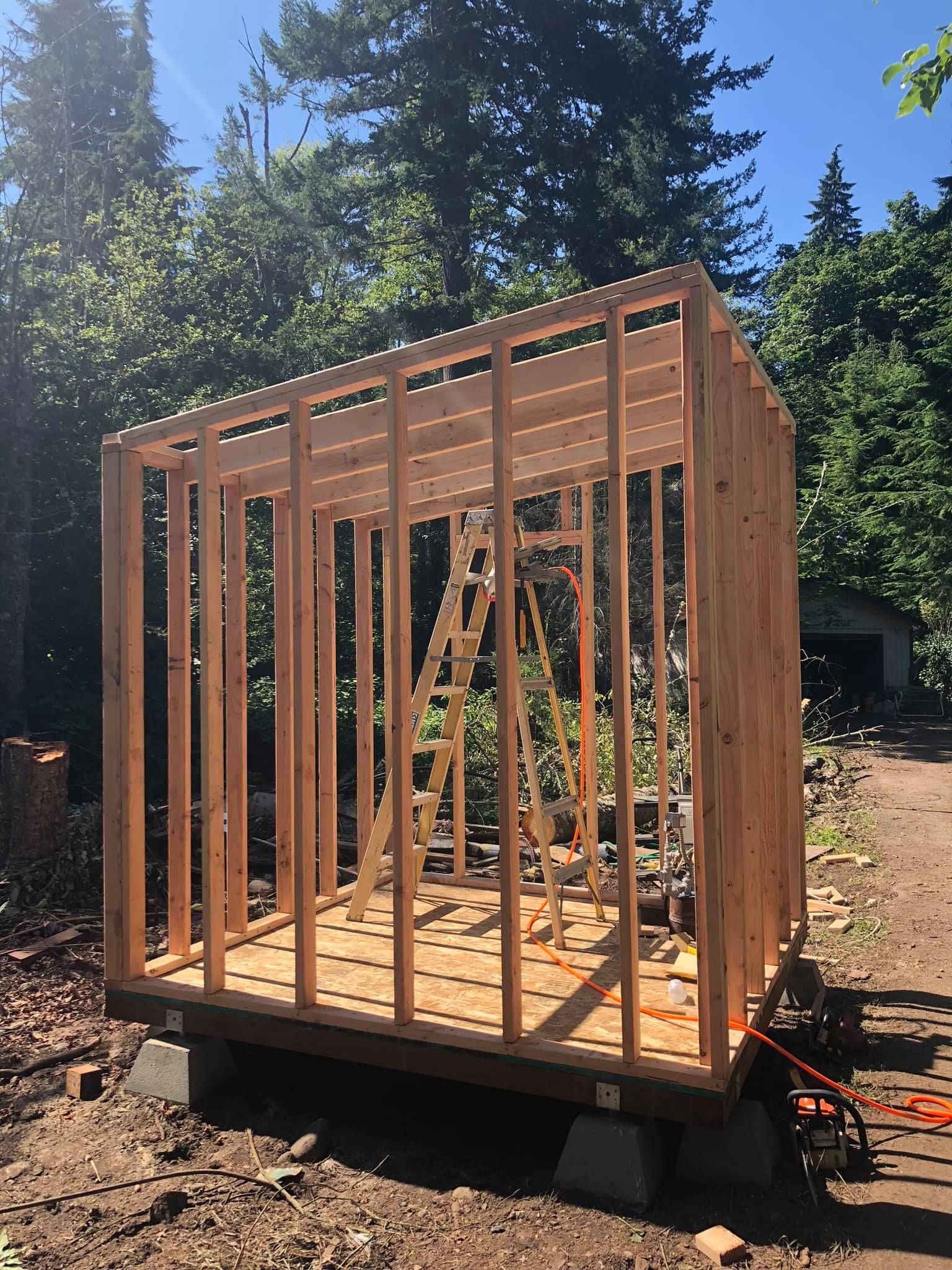 A wooden structure is being built in the middle of a dirt field.