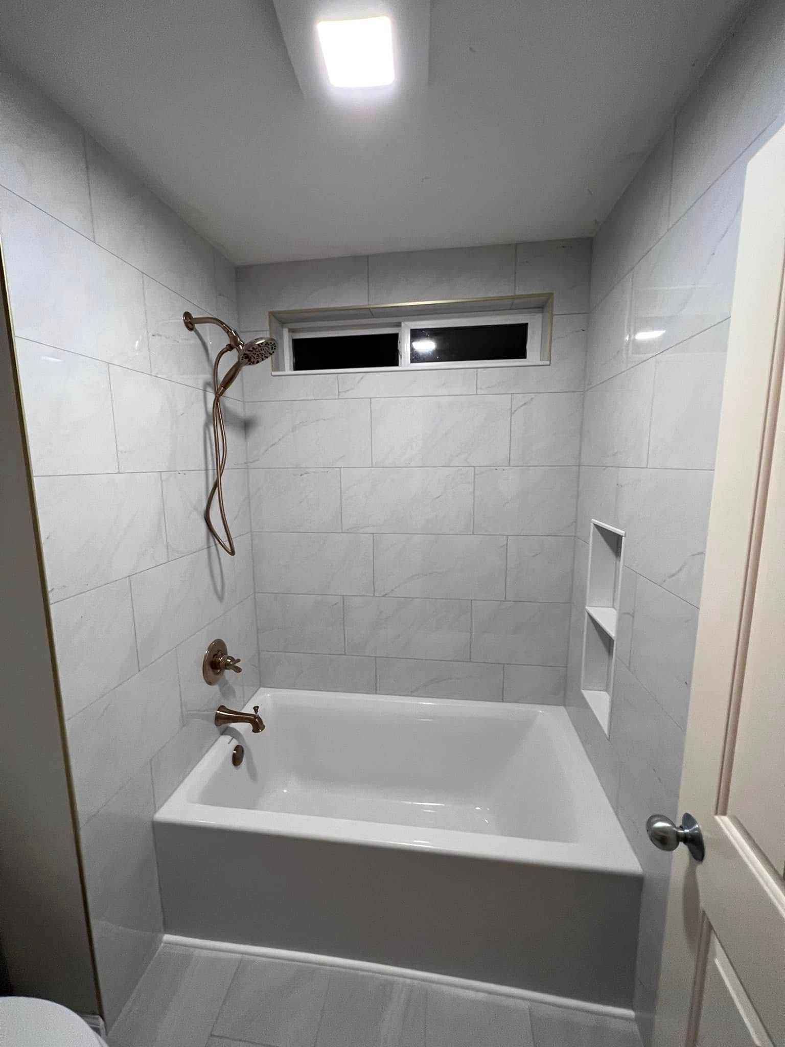 A bathroom with a bathtub and a shower.
