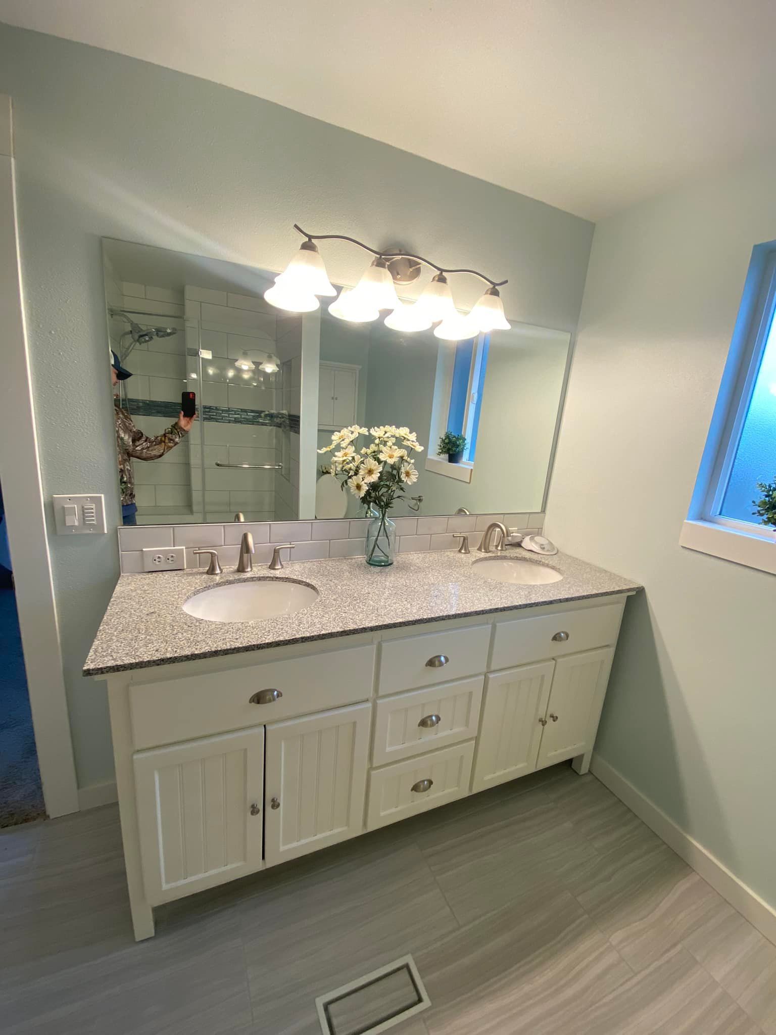 A bathroom with two sinks and a large mirror.