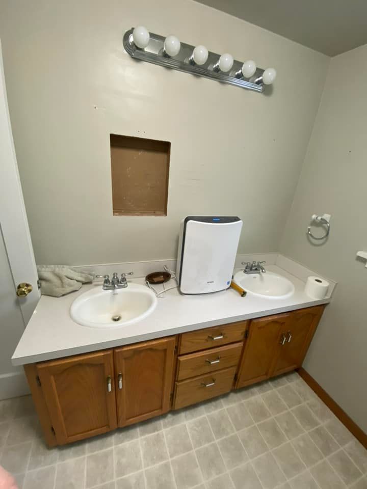 A bathroom with two sinks and a light fixture.