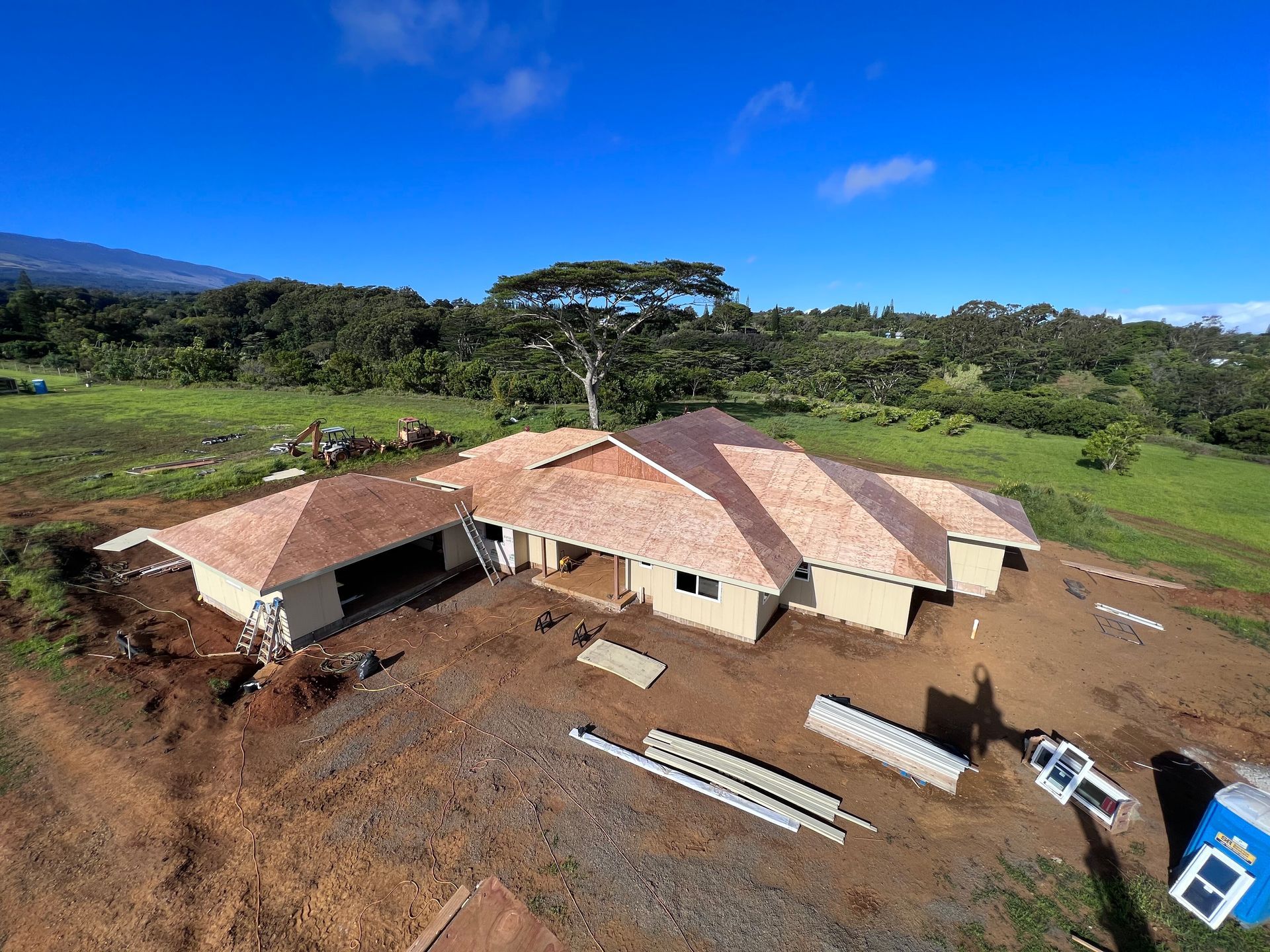 A house with a wooden deck and a garage underneath it.