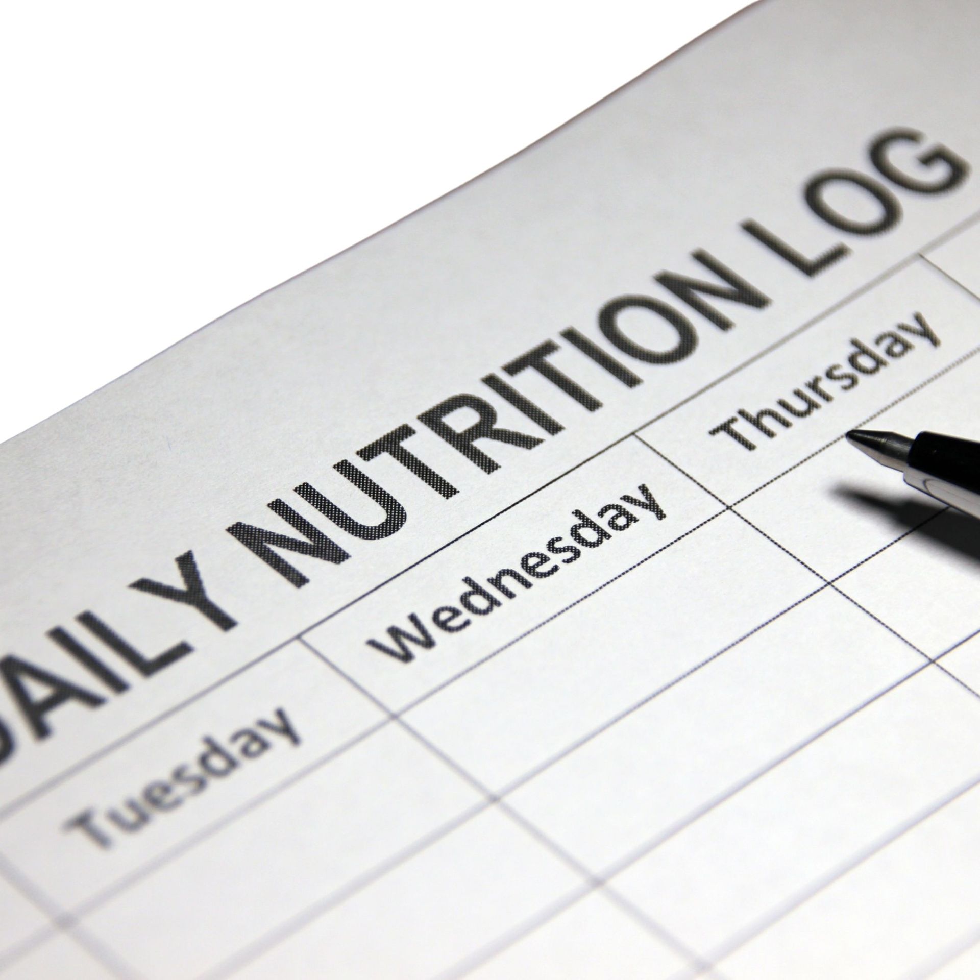 Daily nutrition log, partially filled out, with a pen resting on the paper.