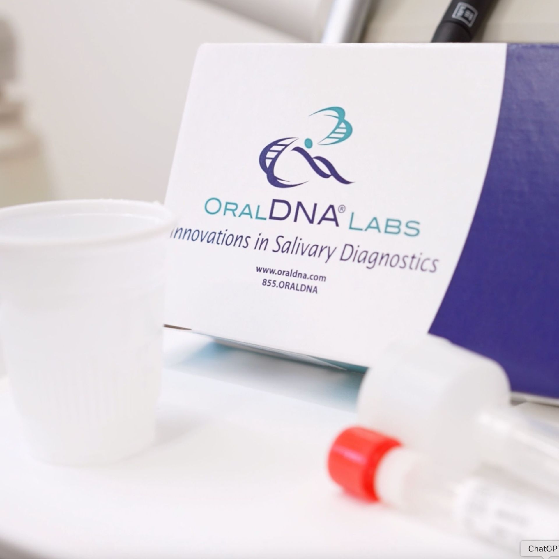 Box of OralDNA Labs salivary diagnostics kit with tubes and cup.