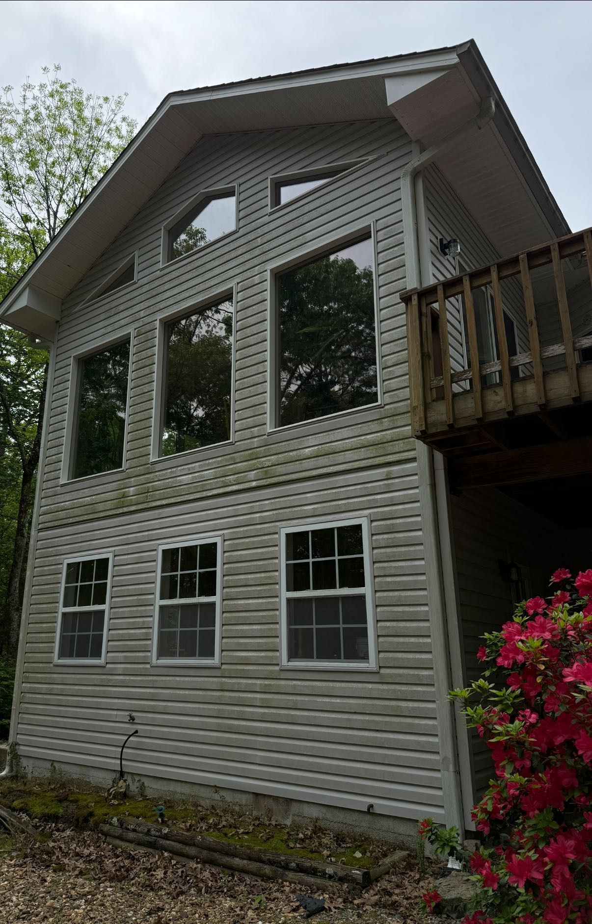 Exterior of beige house with dark smoke stains near two windows and a vent
