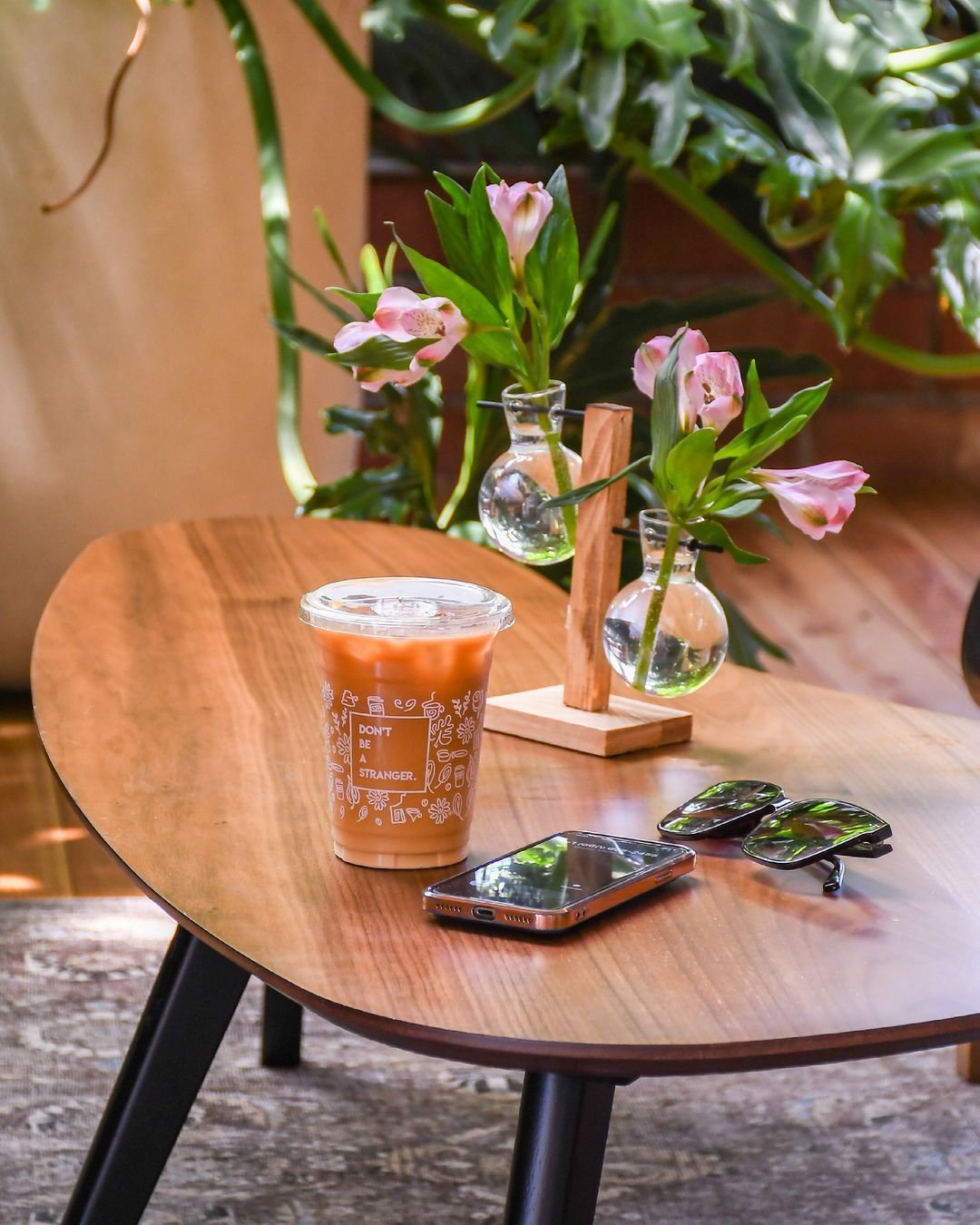 Fresh flower arrangement with pink roses and greenery on a wooden table at Acola Coffee Company Columbia MO