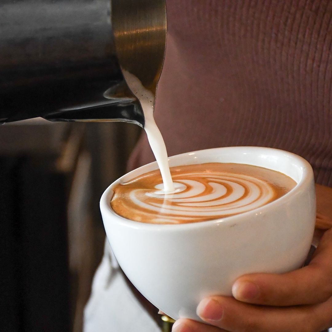 Barista pouring latte art at Acola Coffee Company Columbia MO