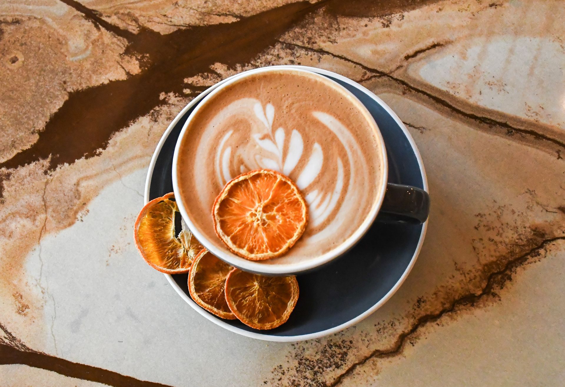 Latte art coffee with dried orange slices at Acola Coffee Company Columbia MO