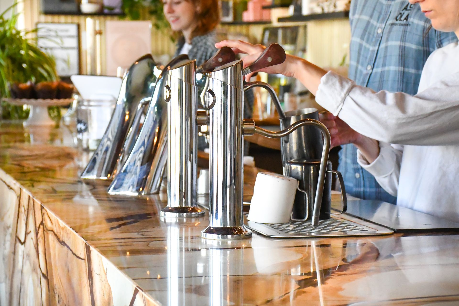 Barista behind the espresso bar at Acola Coffee Company Columbia MO