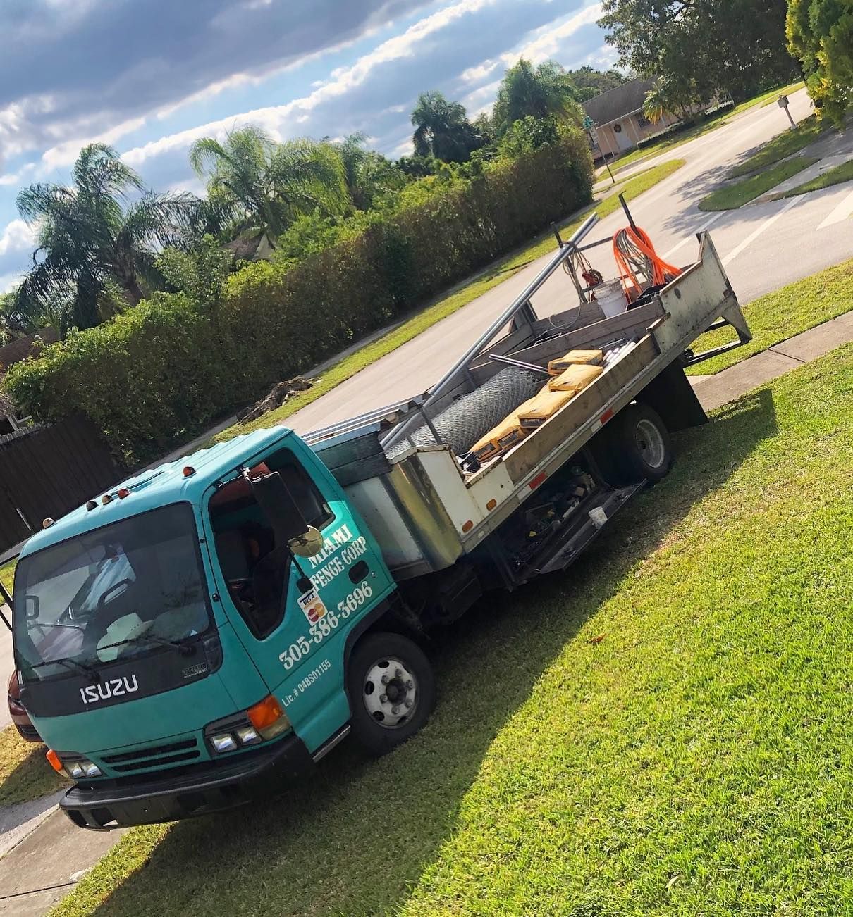 A blue isuzu truck is parked on the side of the road
