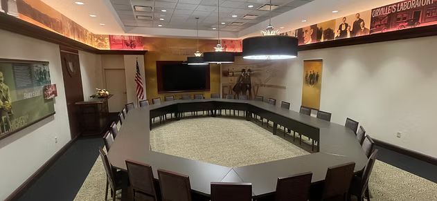 A large conference room with a round table and chairs.