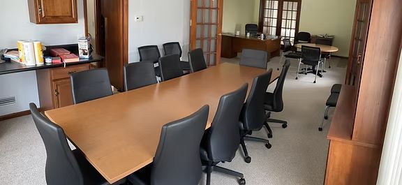 A conference room with a long table and chairs.