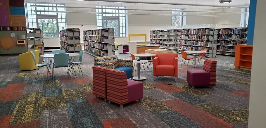 There are many chairs and tables in the library.
