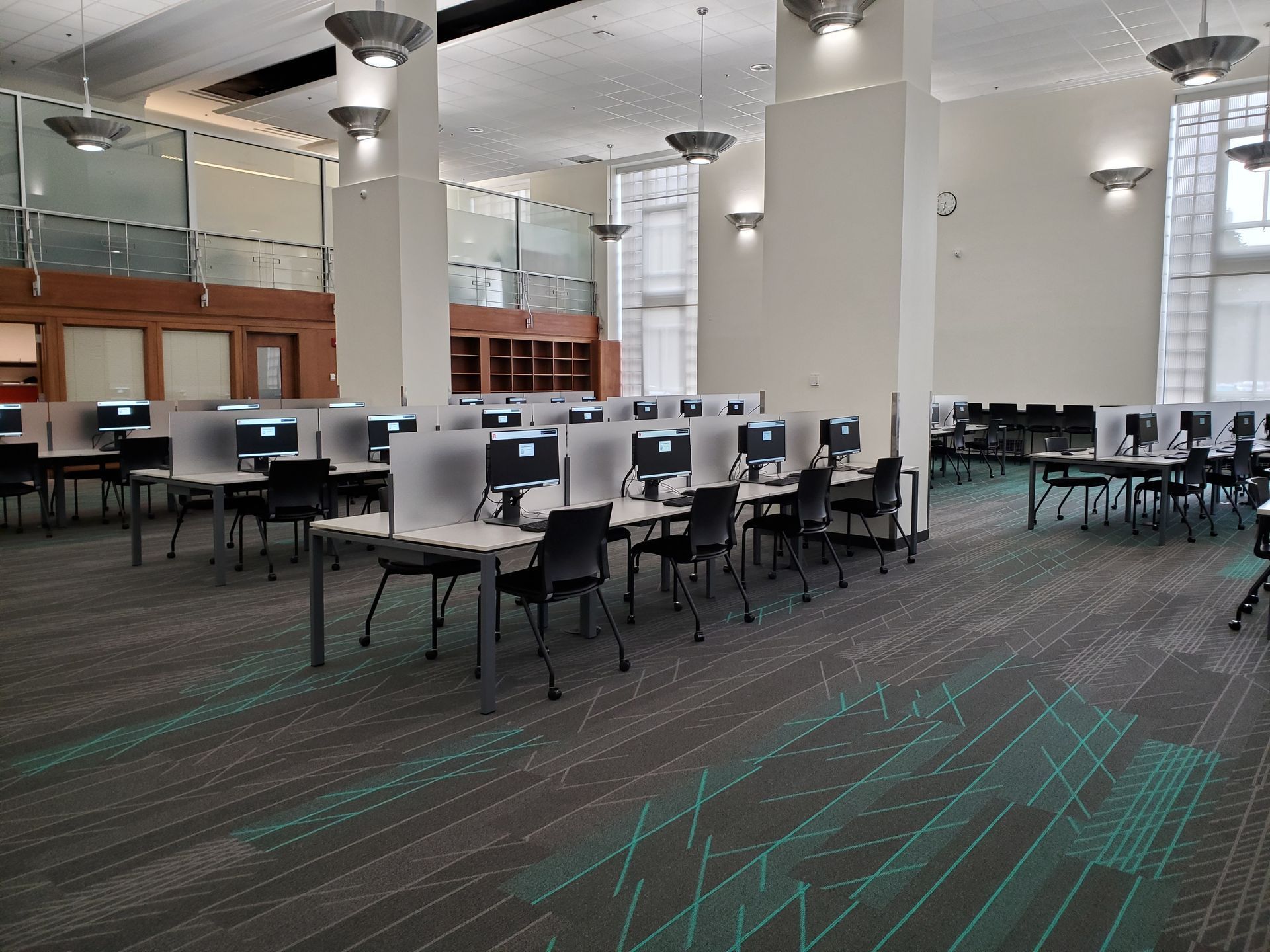A large room with tables and chairs filled with computers