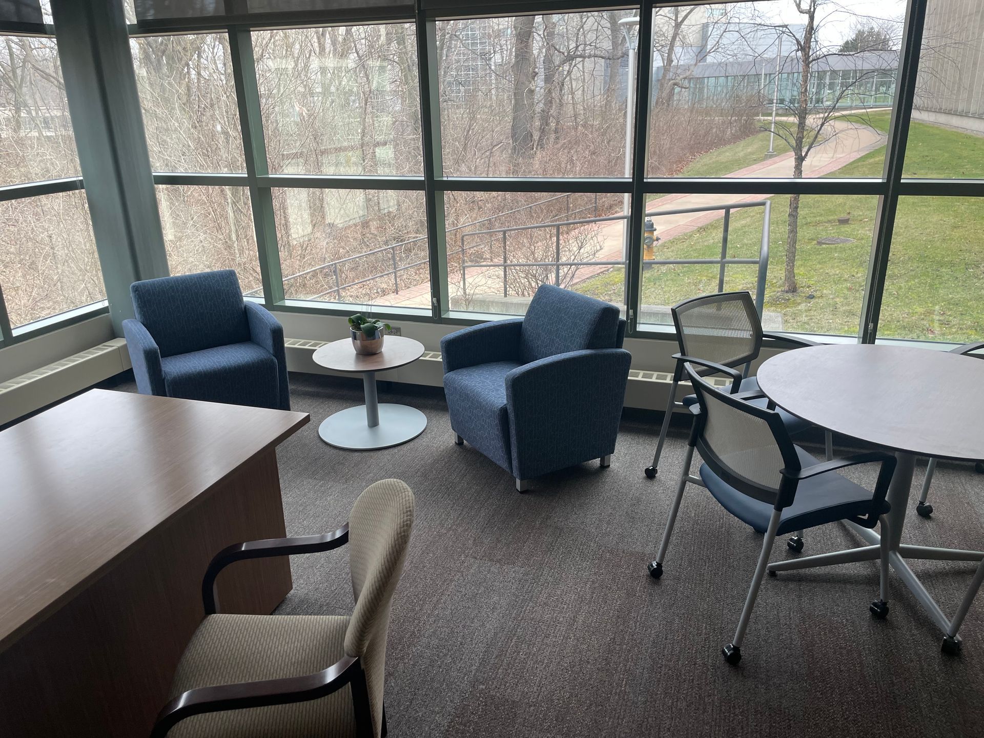 A room with chairs , a table , and a large window.