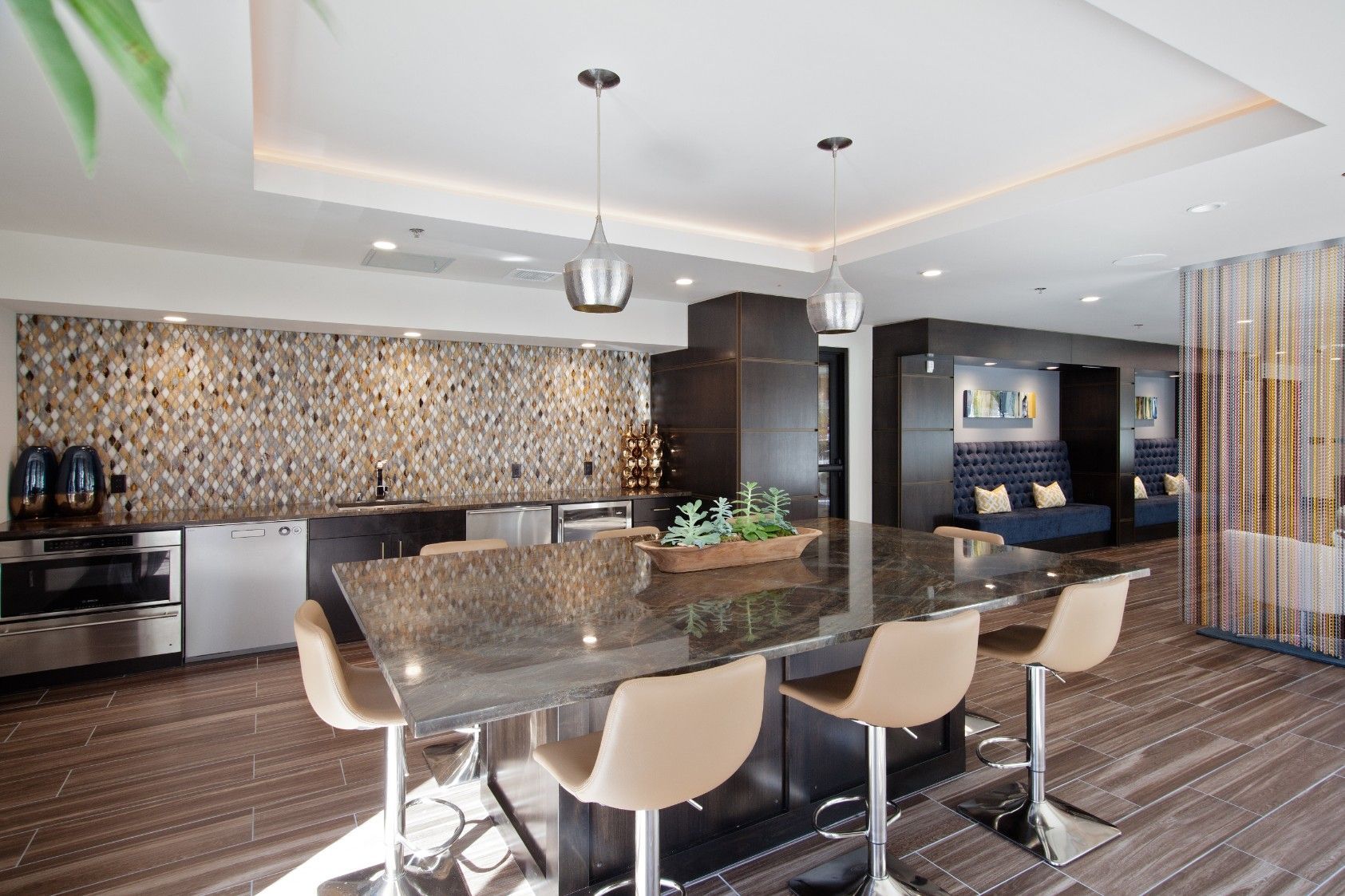 Modern kitchen with a large island, pendant lights, and bar stools in an open-plan interior