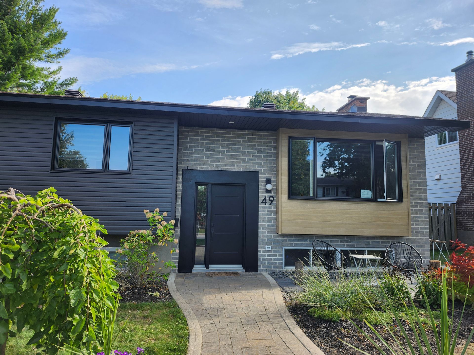 La façade d'une maison avec une allée en briques qui y mène.