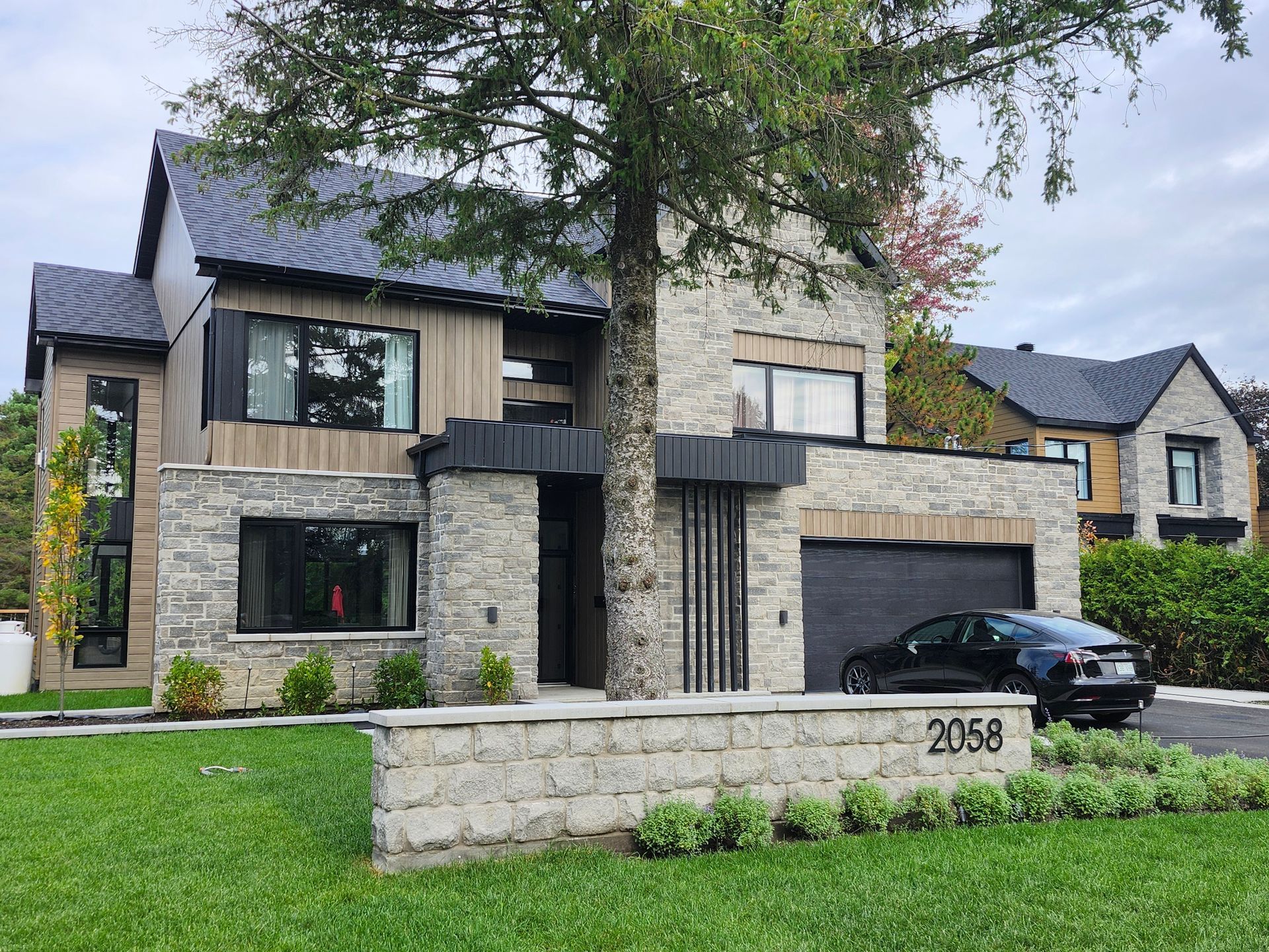 Une grande maison avec une voiture garée devant.