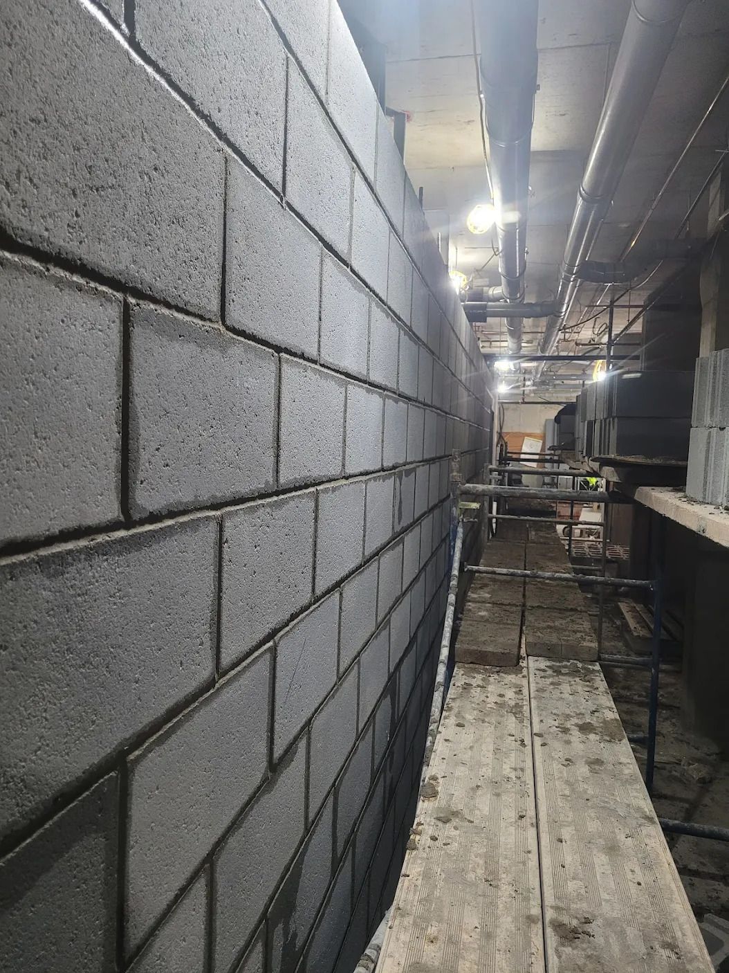 Un mur de briques est en train d'être construit dans un bâtiment.