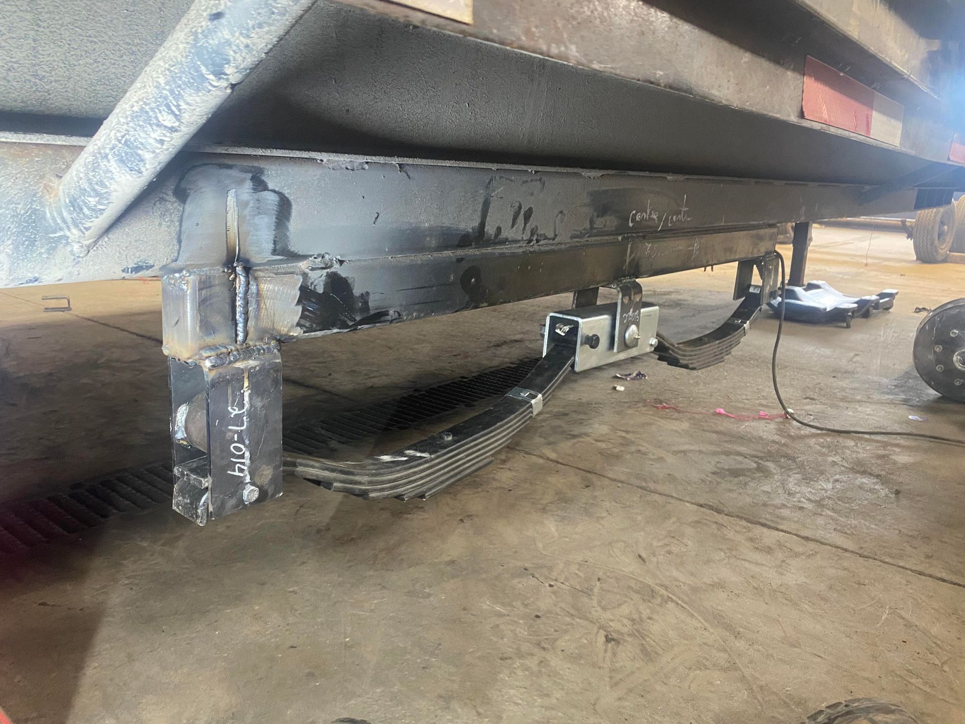 Une remorque est posée sur le sol dans un garage.