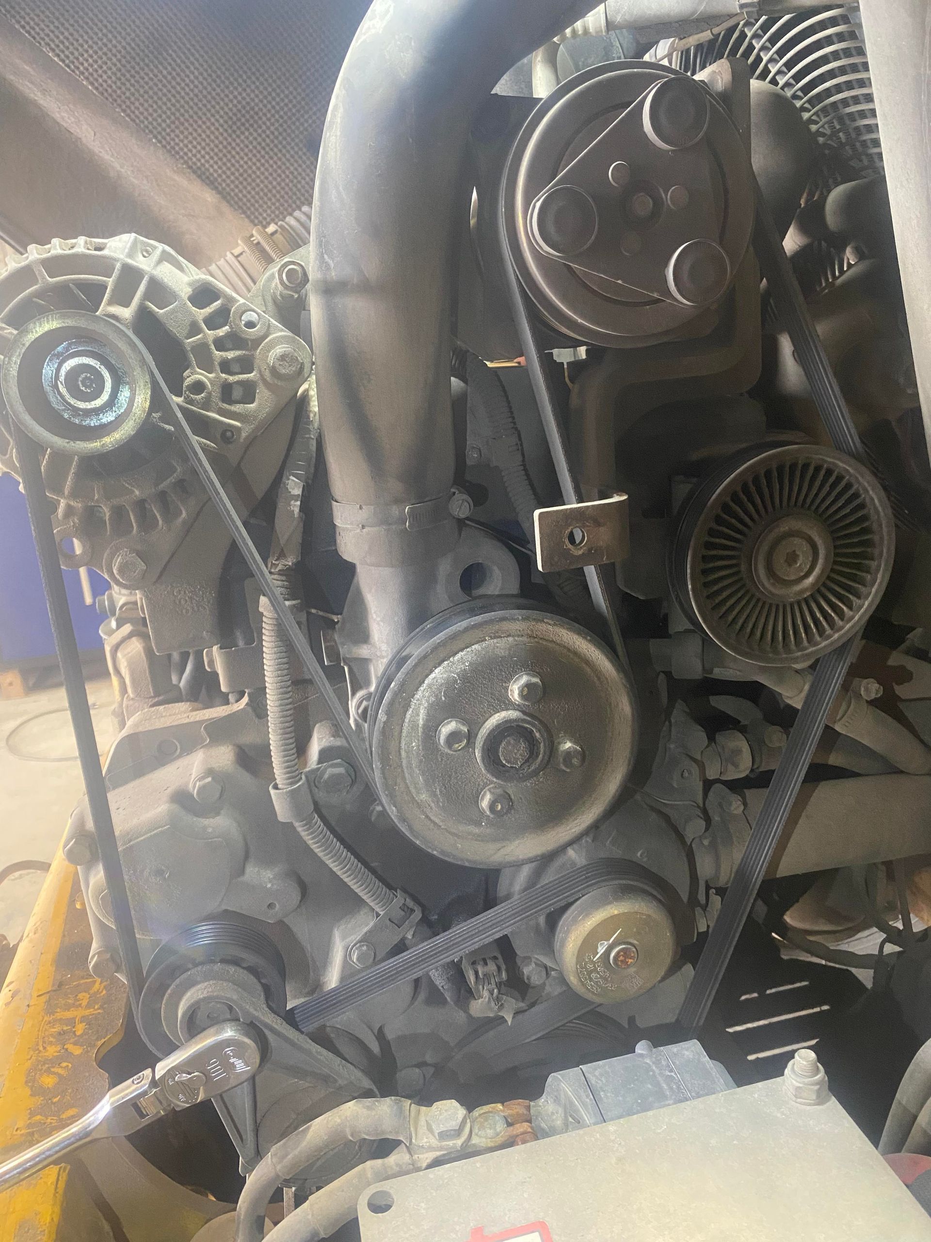 Un gros plan d'un moteur de voiture avec courroies et alternateurs.