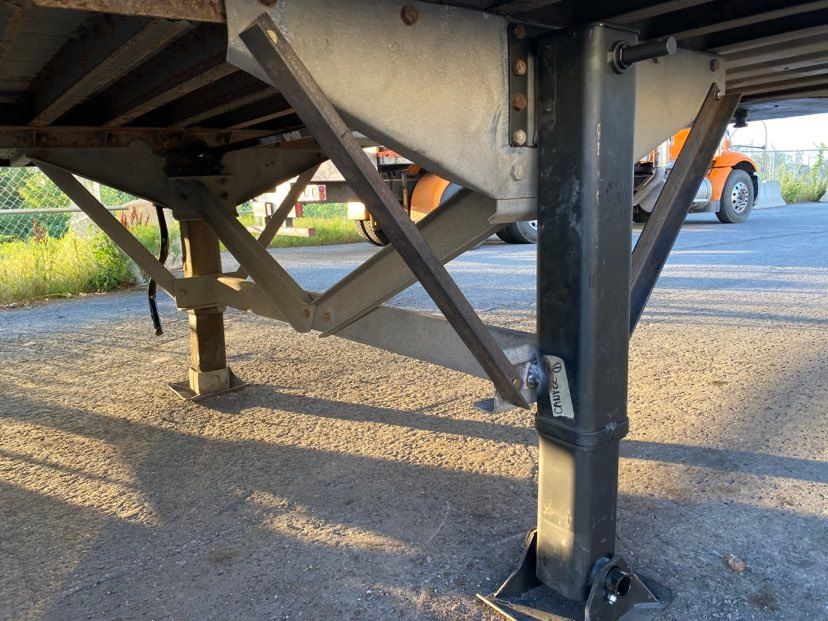 Un camion est garé sur un parking à côté d'une remorque.
