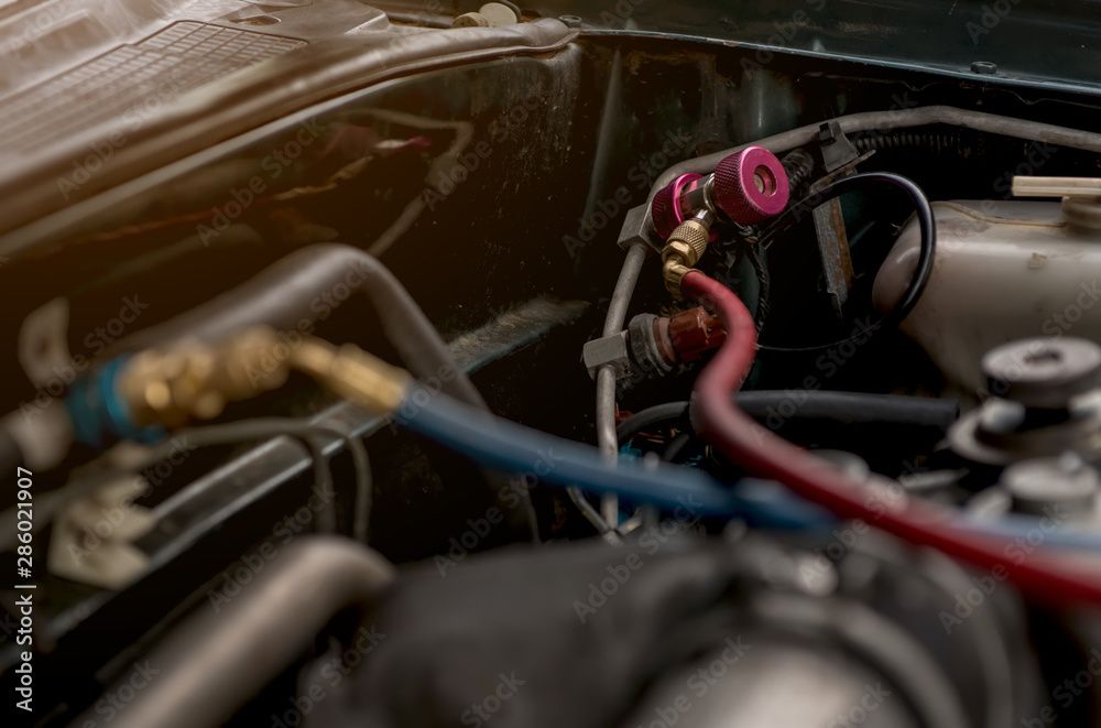 Un gros plan d'un moteur de voiture avec un tuyau attaché dessus.