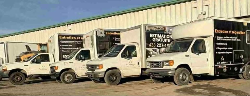 Camions blancs stationnés devant un bâtiment ; logo de l'entreprise sur les côtés.