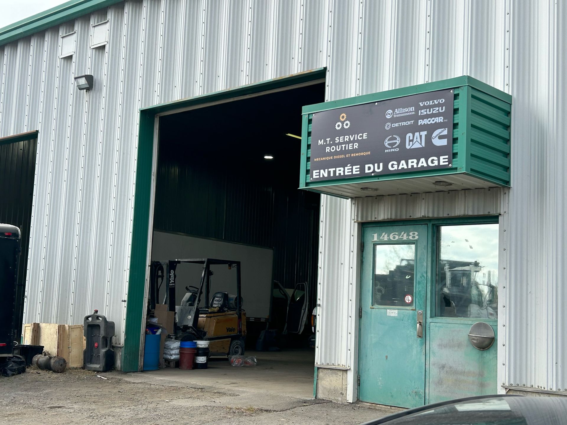 Une voiture est garée devant un garage avec une porte verte
