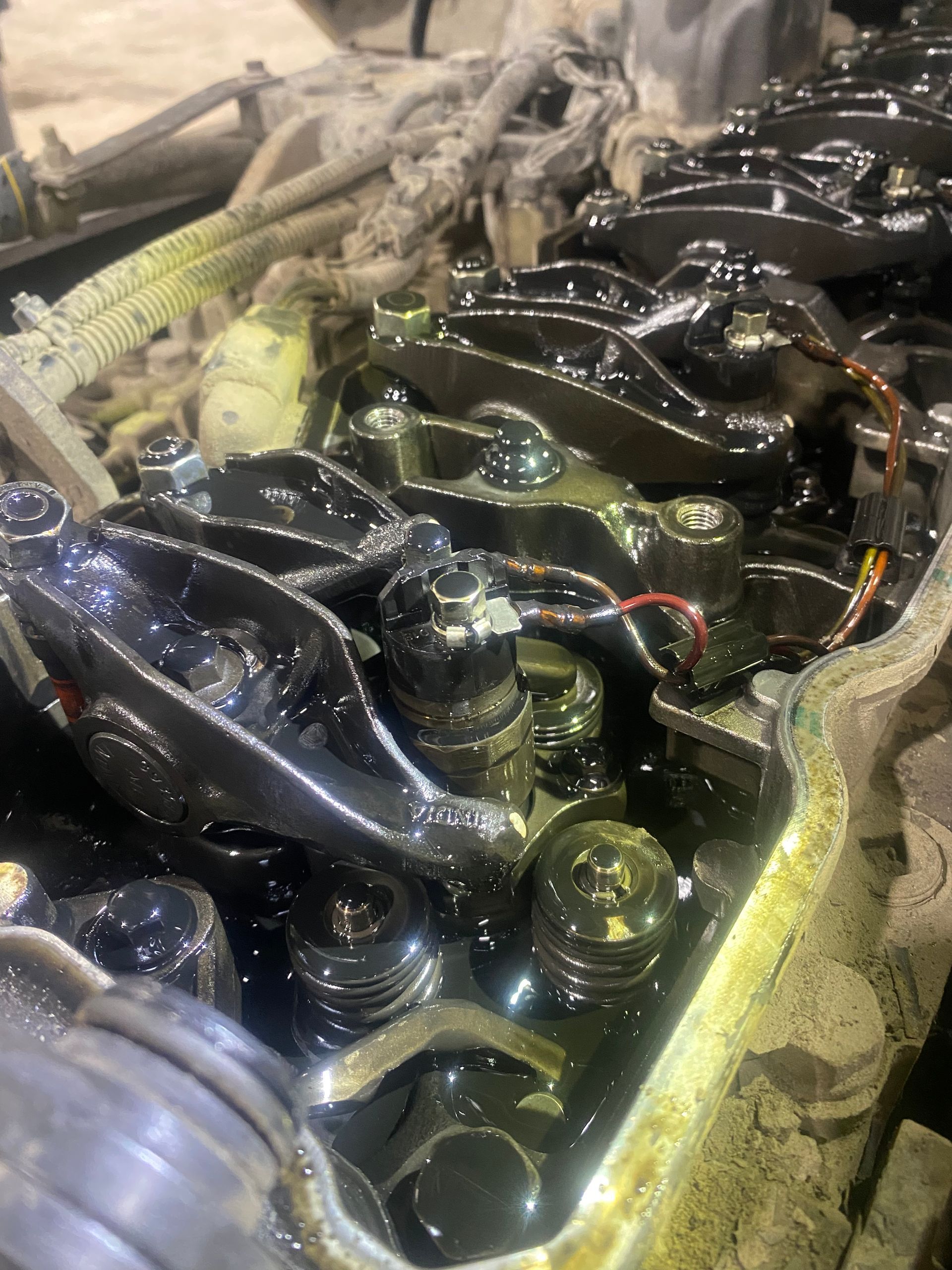 Un gros plan d'un moteur de voiture avec beaucoup d'huile dessus.