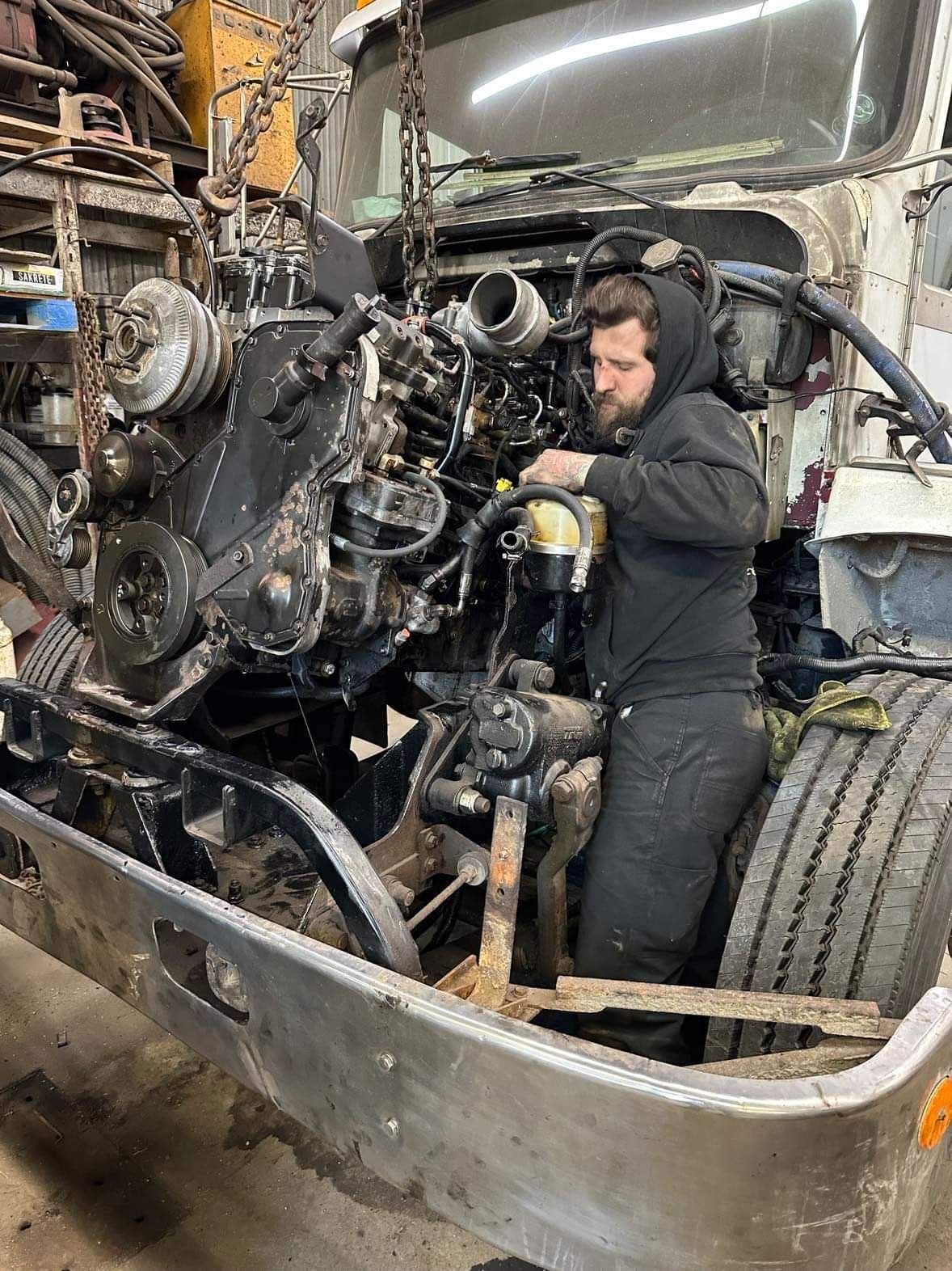 Un homme travaille sur le moteur d'un camion.