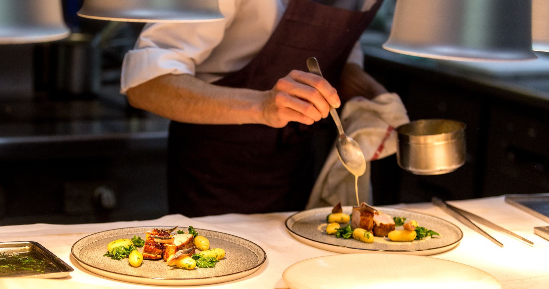 Scratch kitchen chef plating a freshly prepared meal.