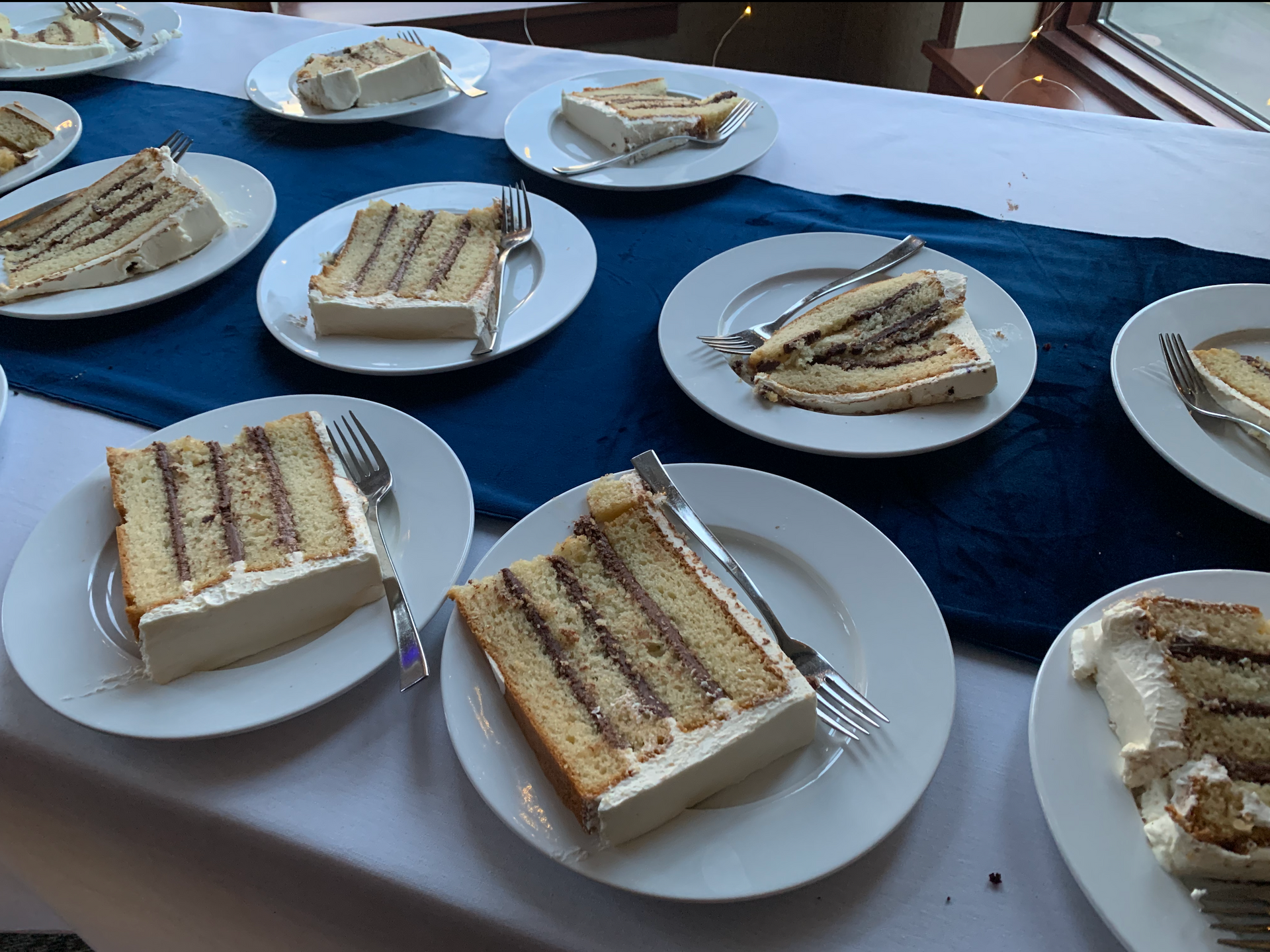 Cake servings on small plates showing the layers of chocolate buttercream filling in a vanilla wedding cake