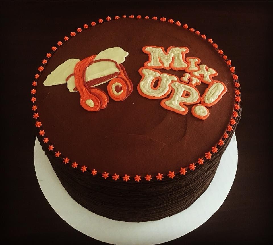 Single tier, 4-layered cake with chocolate buttercream finish and the Mix It Up brand logo on it for decoration.