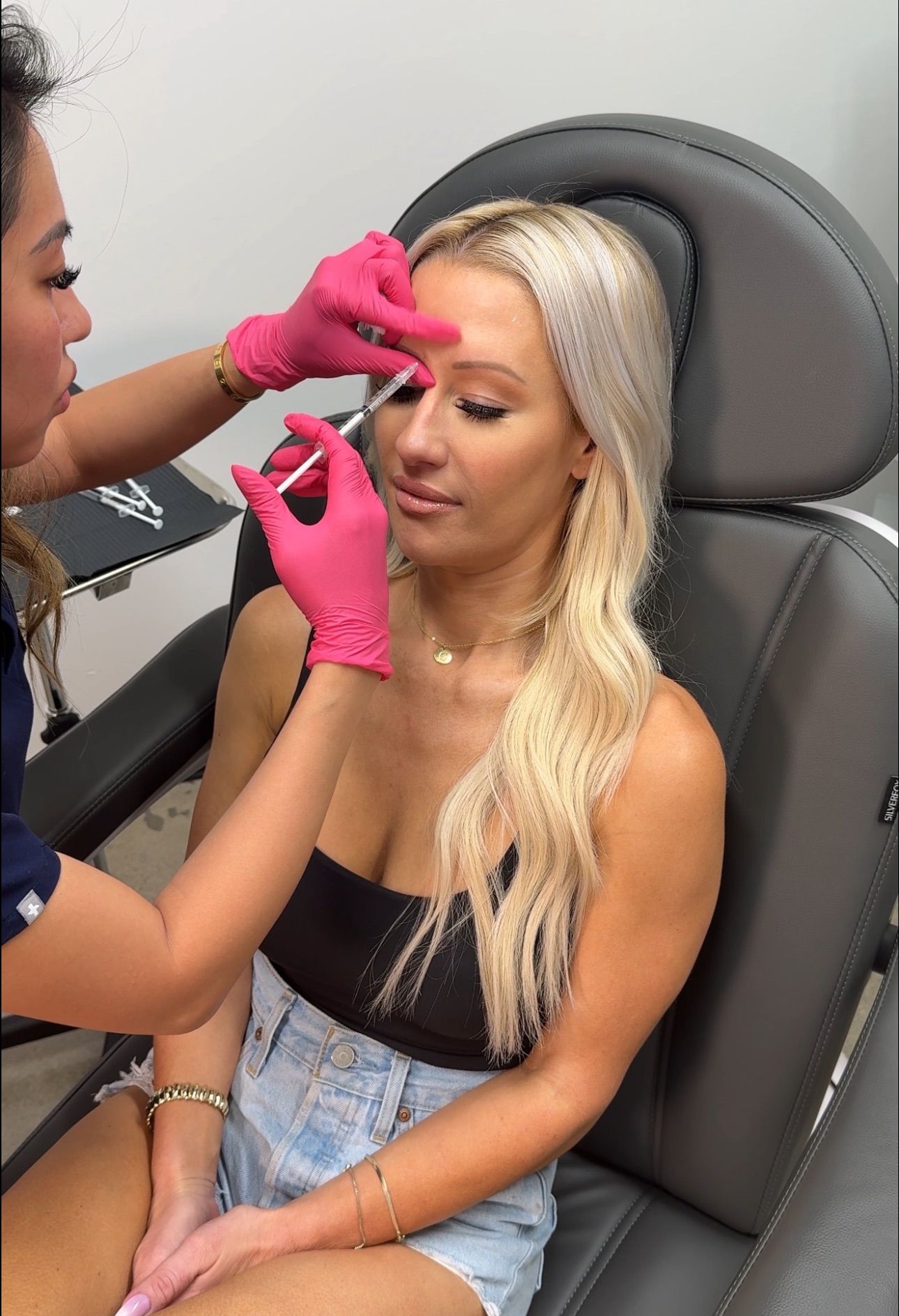 A woman is getting a botox injection in her face.