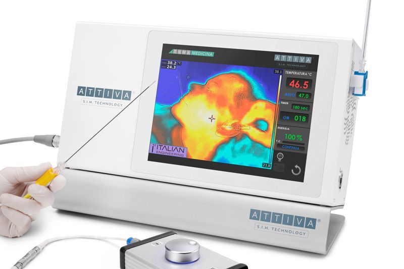 A person is holding a needle in front of a thermal imaging device.