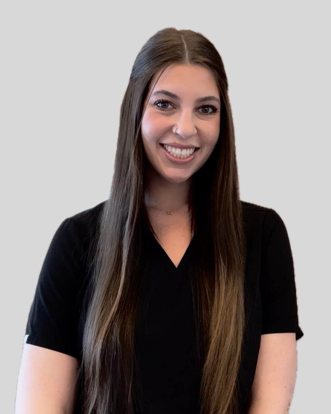 A woman with long hair is wearing a black shirt and smiling.