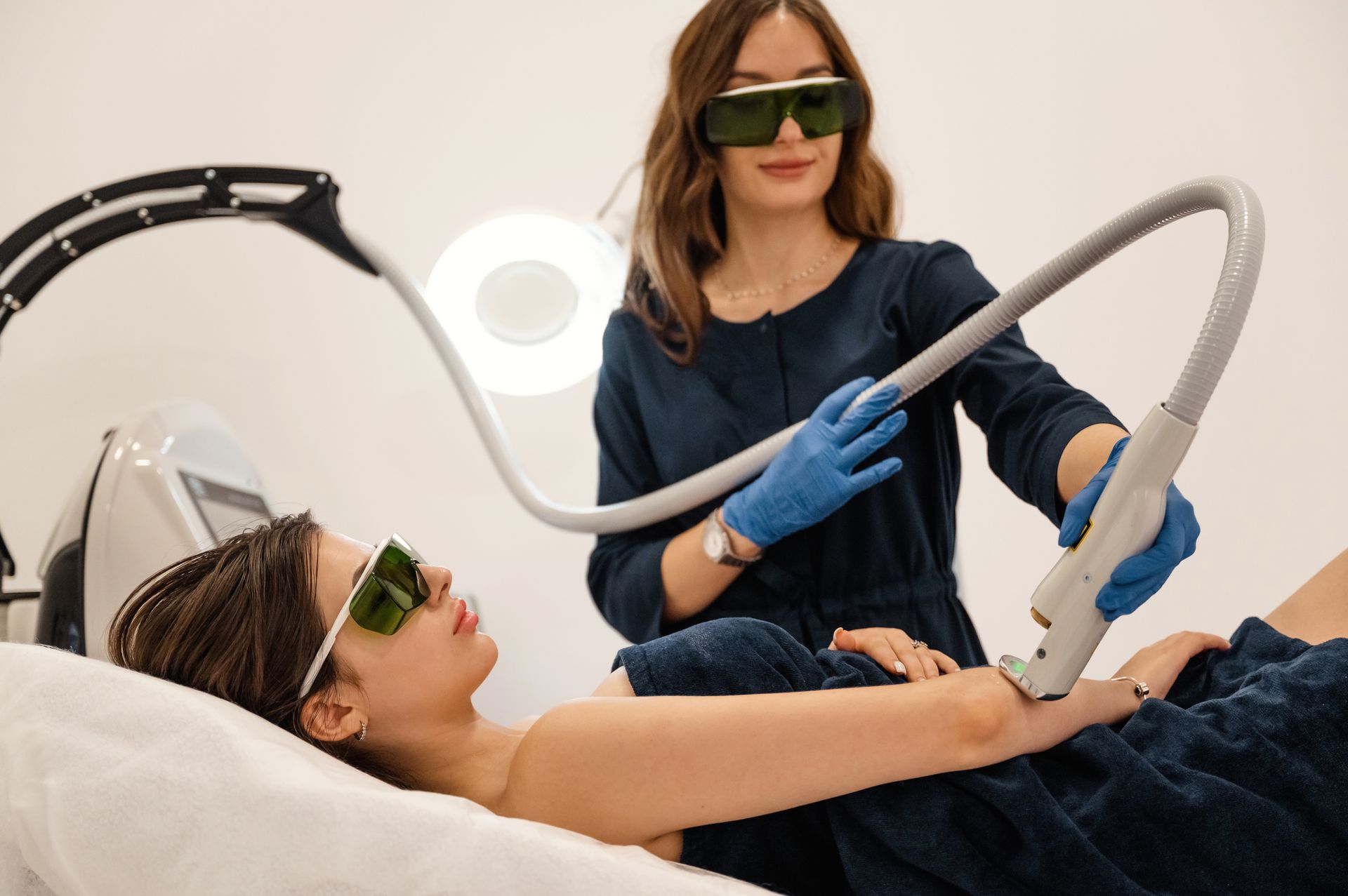 A woman is getting a laser hair removal treatment on her arm.