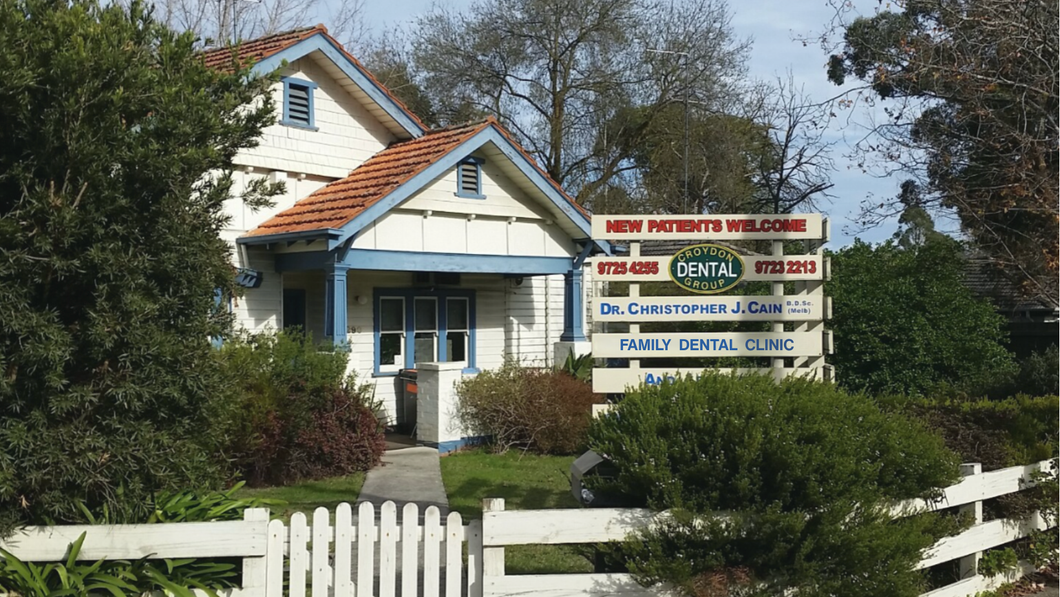 A small dental clinic in a house, with a sign that says 