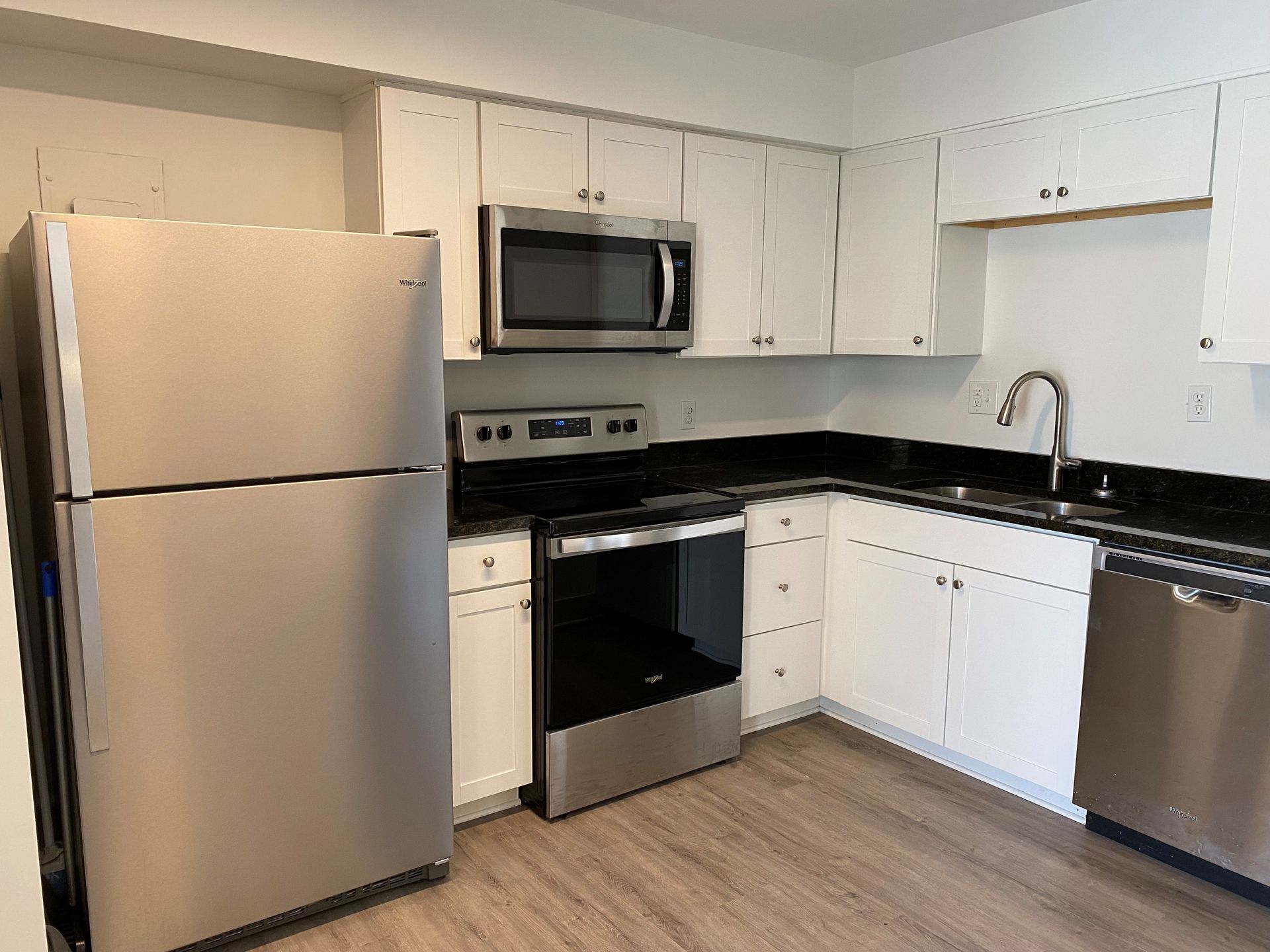 A kitchen with stainless steel appliances and white cabinets