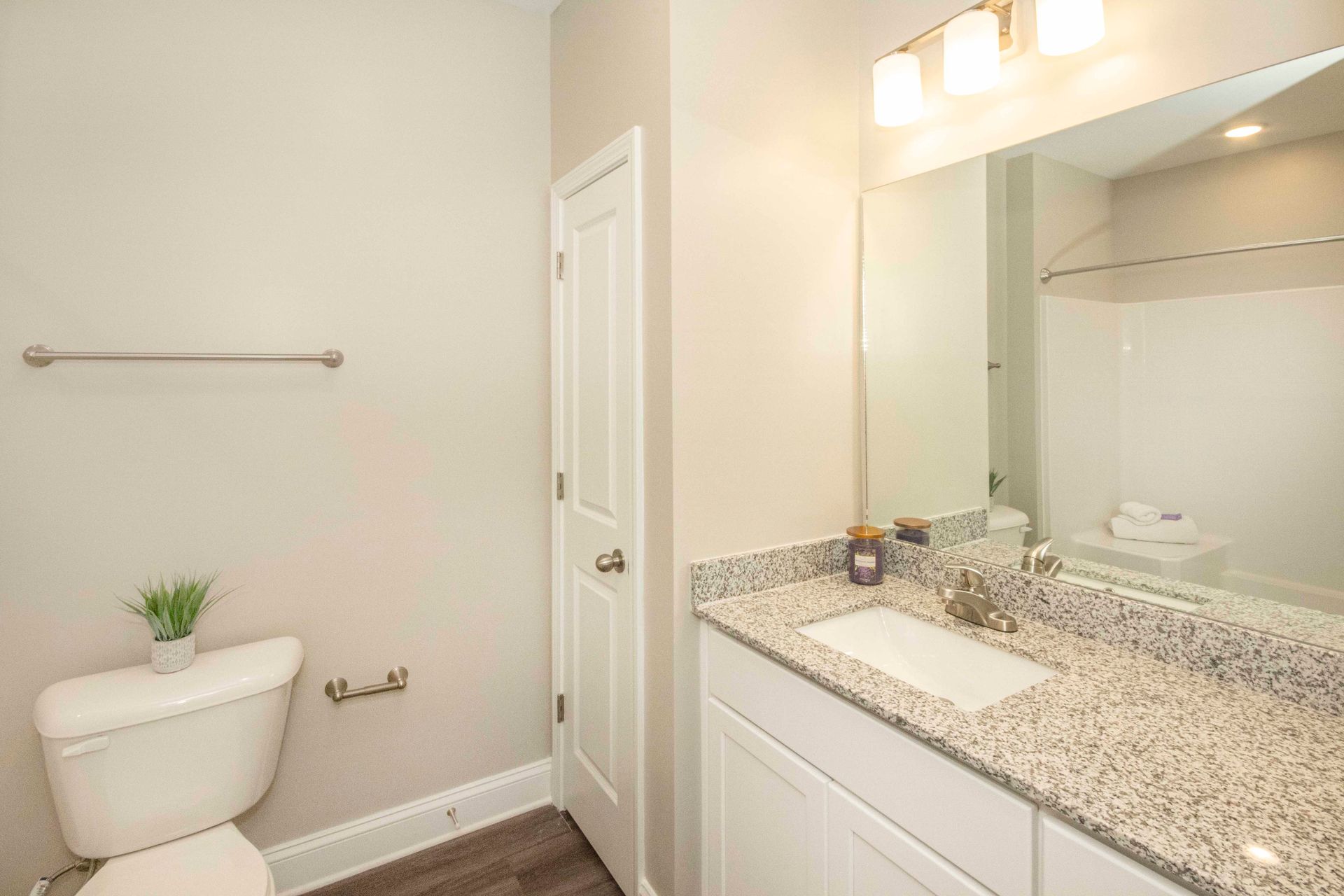 A bathroom with a toilet , sink , and mirror.
