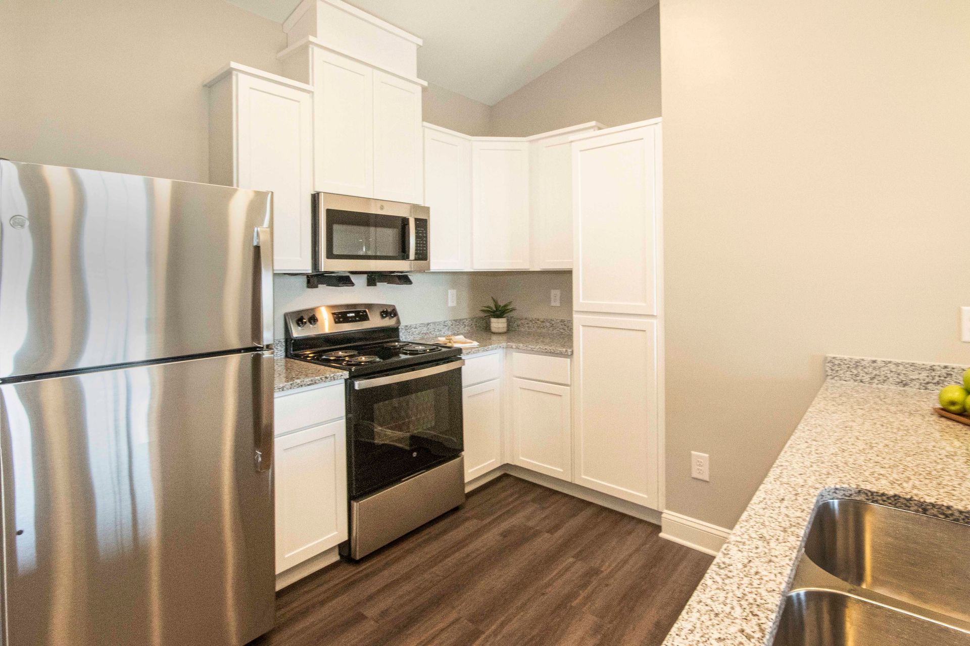 A kitchen with a stainless steel refrigerator , stove , microwave and sink.