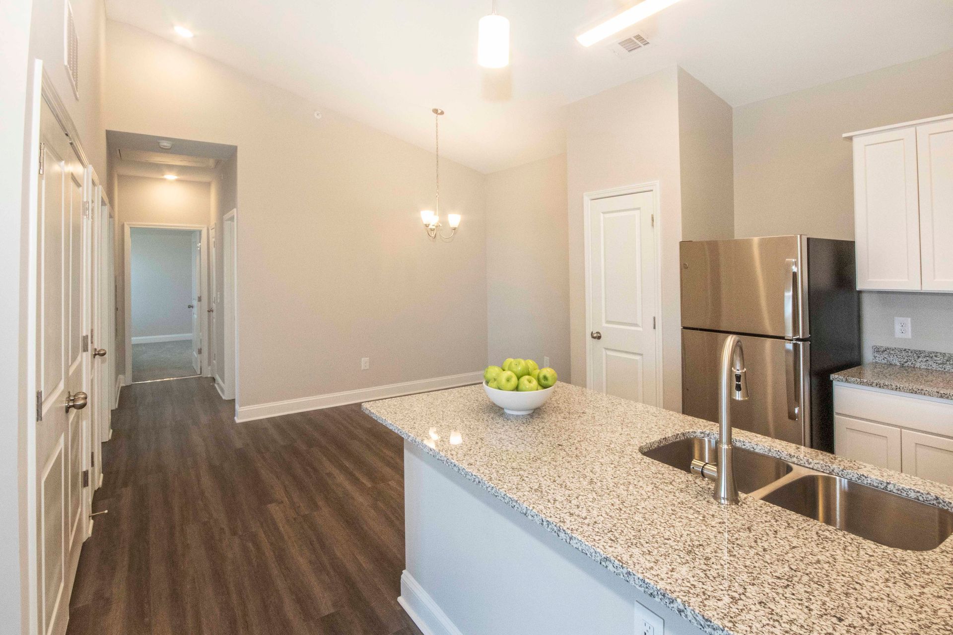 A kitchen with granite counter tops and a stainless steel refrigerator.