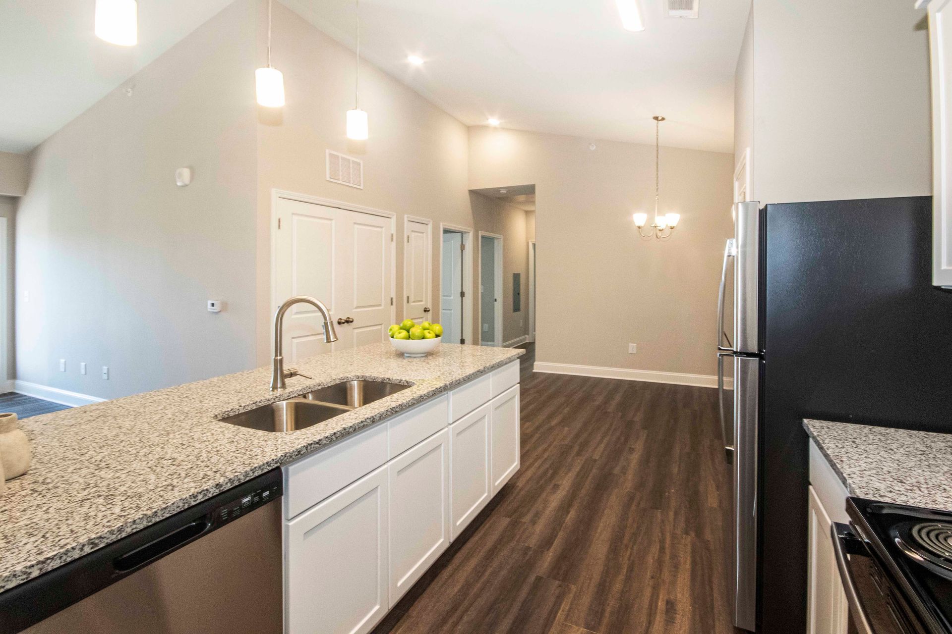 A kitchen with granite counter tops and stainless steel appliances.
