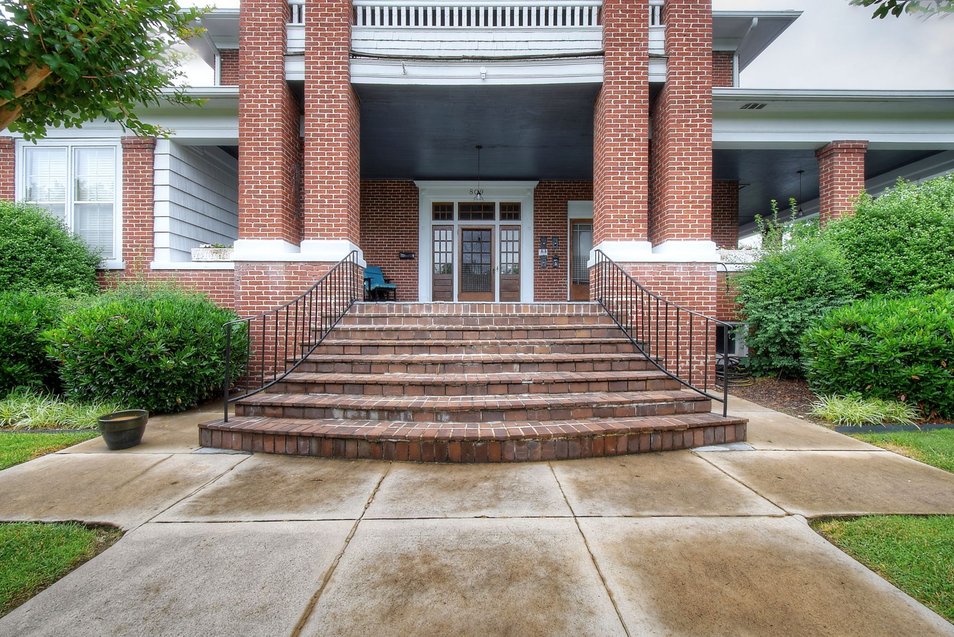 A brick building with stairs leading up to the front door