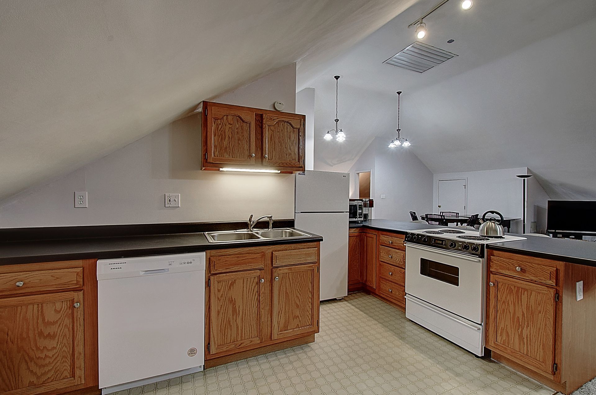 A kitchen with wooden cabinets and white appliances