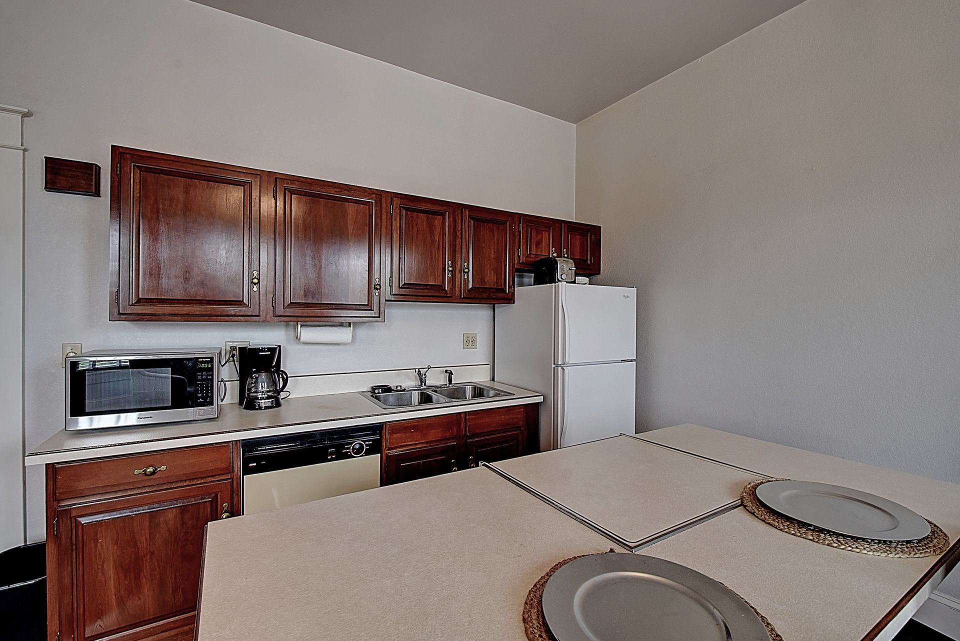 A kitchen with brown cabinets and a white refrigerator