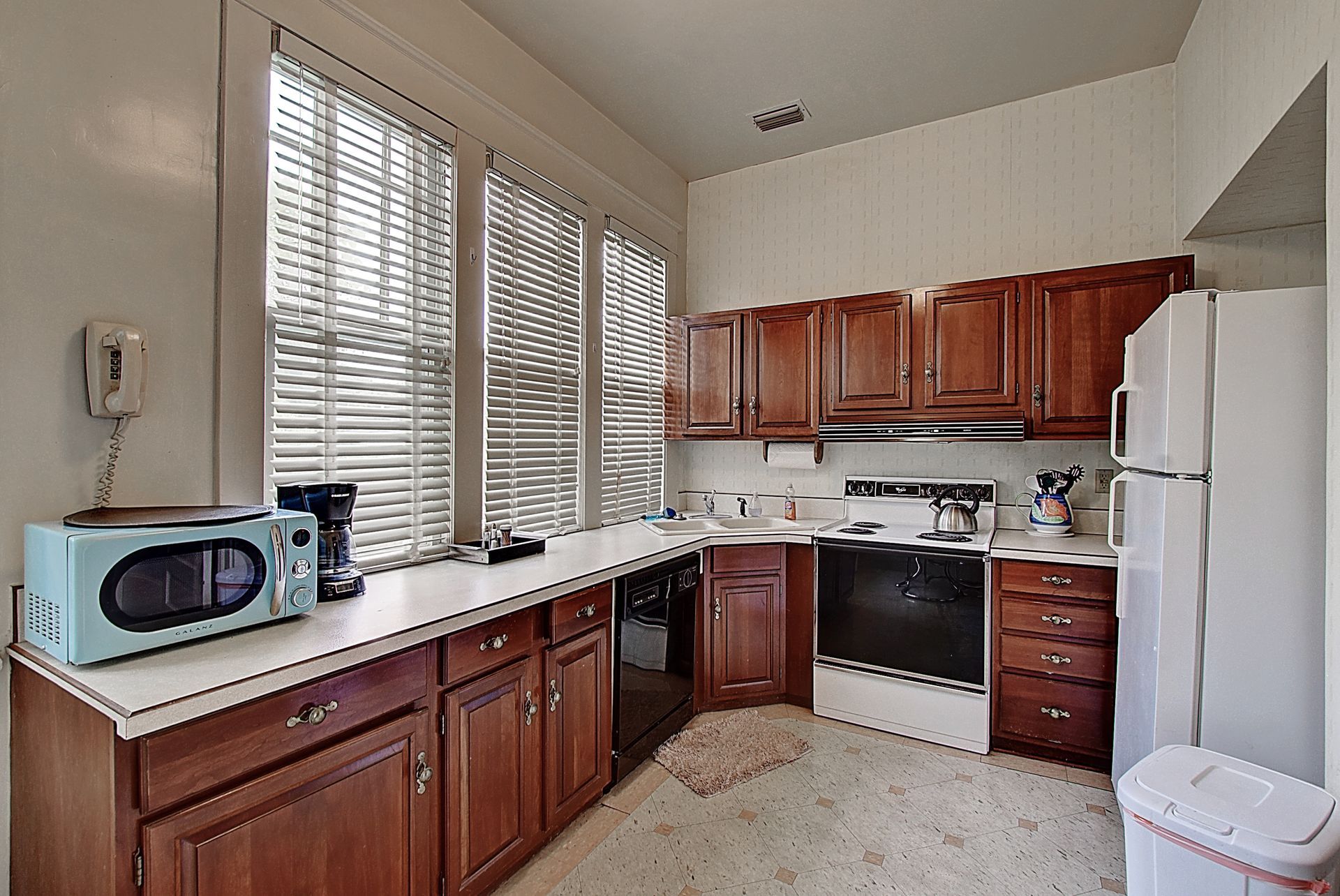 A kitchen with wooden cabinets and white appliances