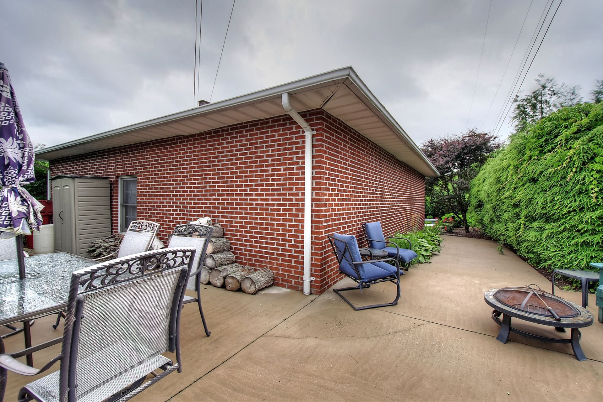 A brick house with a patio area with chairs and umbrellas