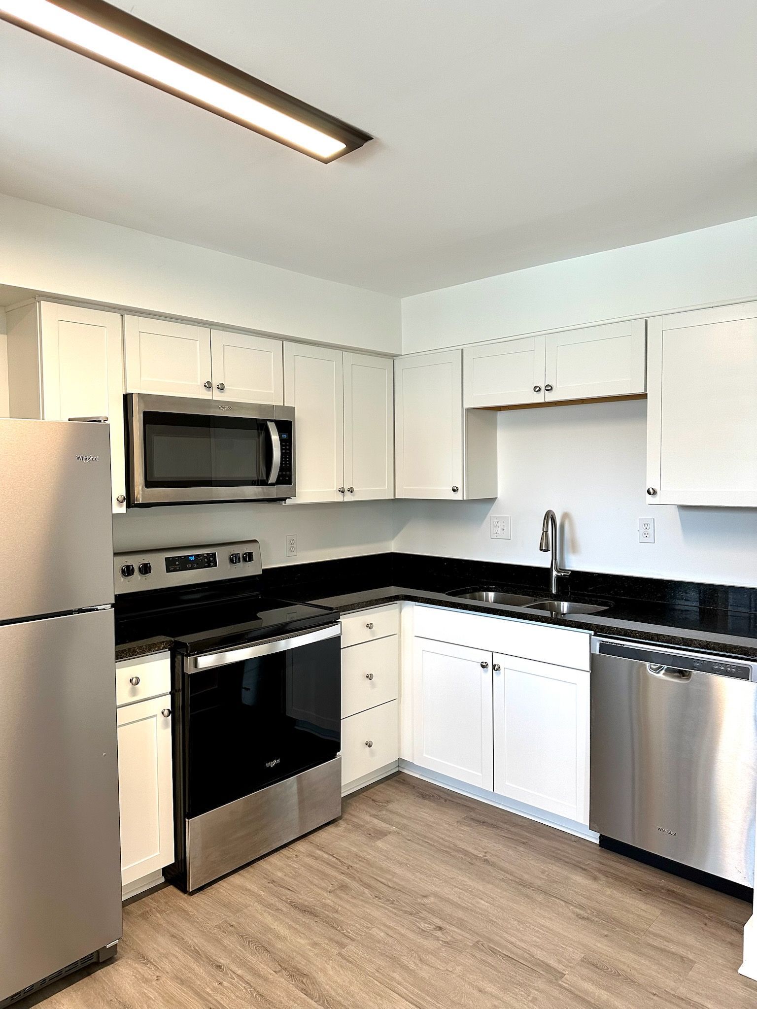 A kitchen with stainless steel appliances and white cabinets