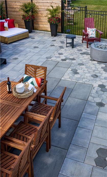 A patio with a table and chairs and a fire pit.